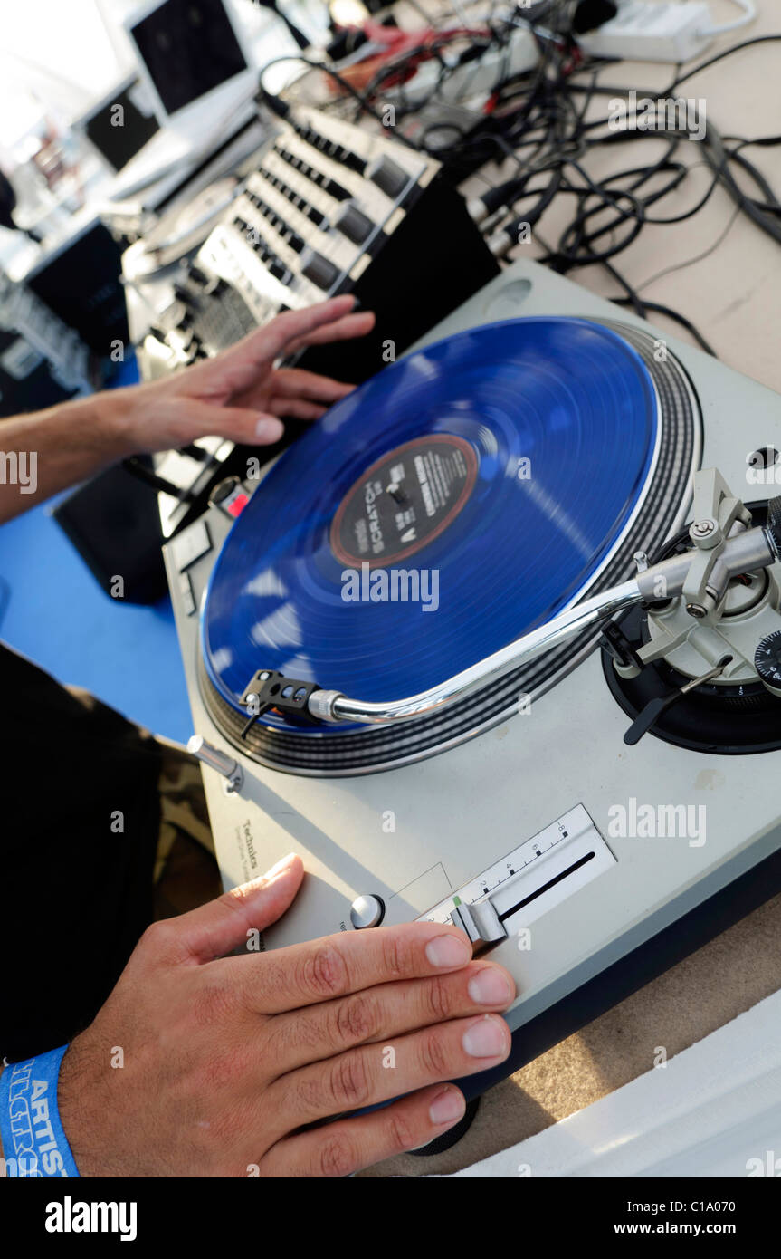 DJ performing live, mixing music using mixer and scratch vinyl record