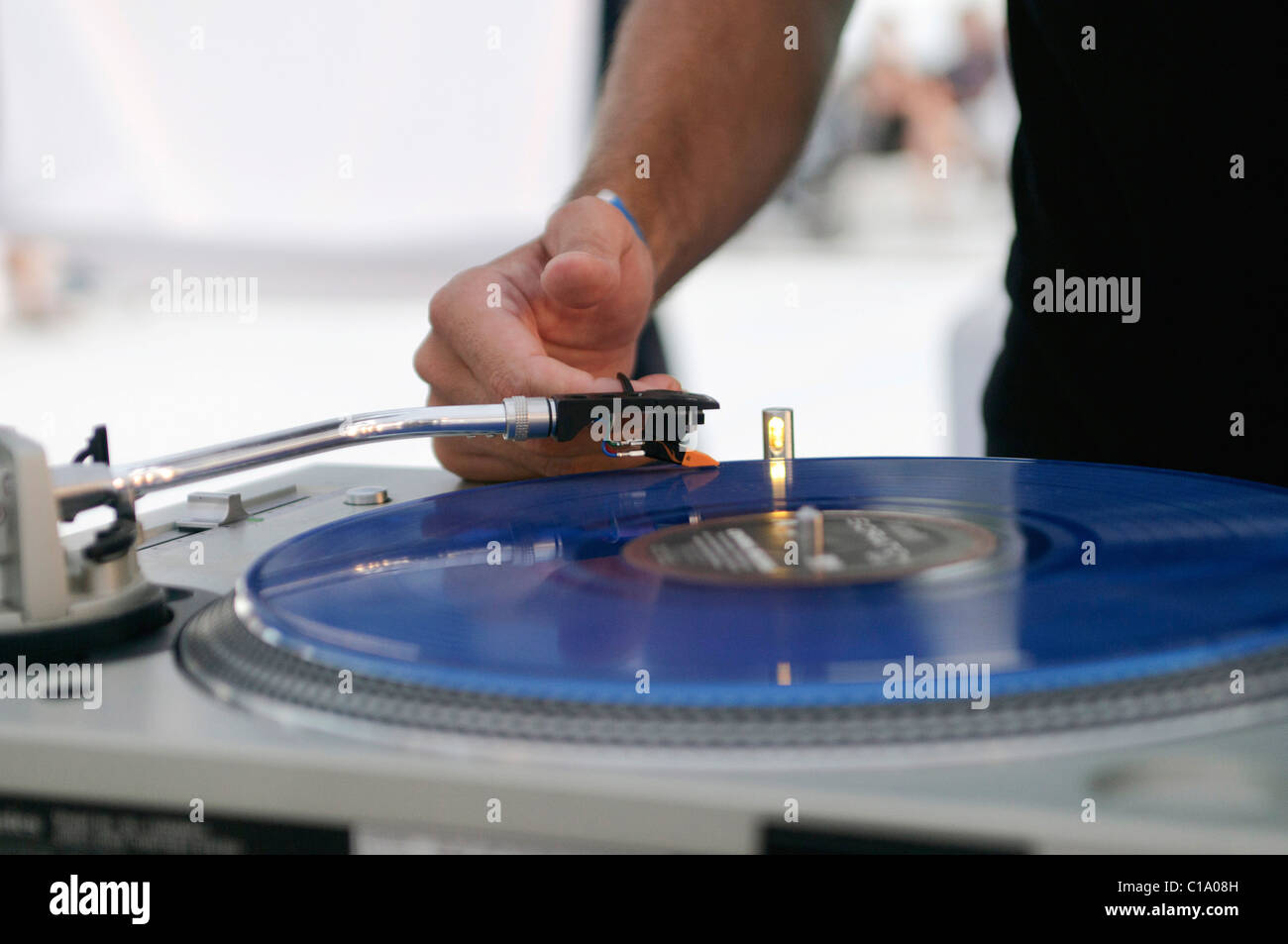 DJ performing live, mixing music using mixer and scratch vinyl record