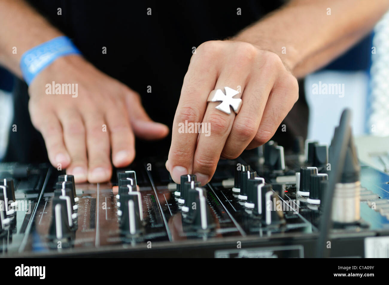 DJ turning the knobs on his mixer Stock Photo Alamy