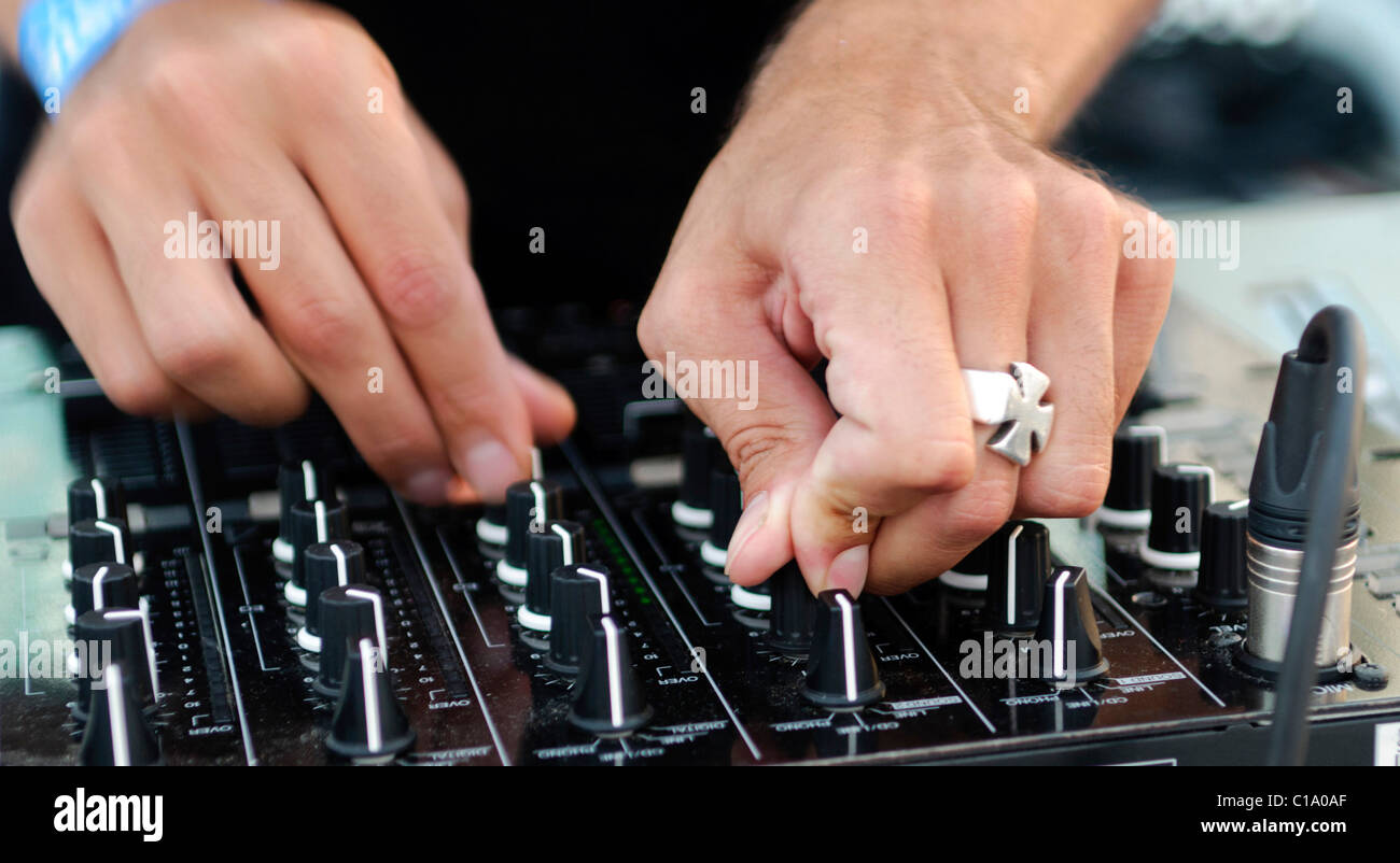 DJ turning the knobs on his mixer Stock Photo Alamy