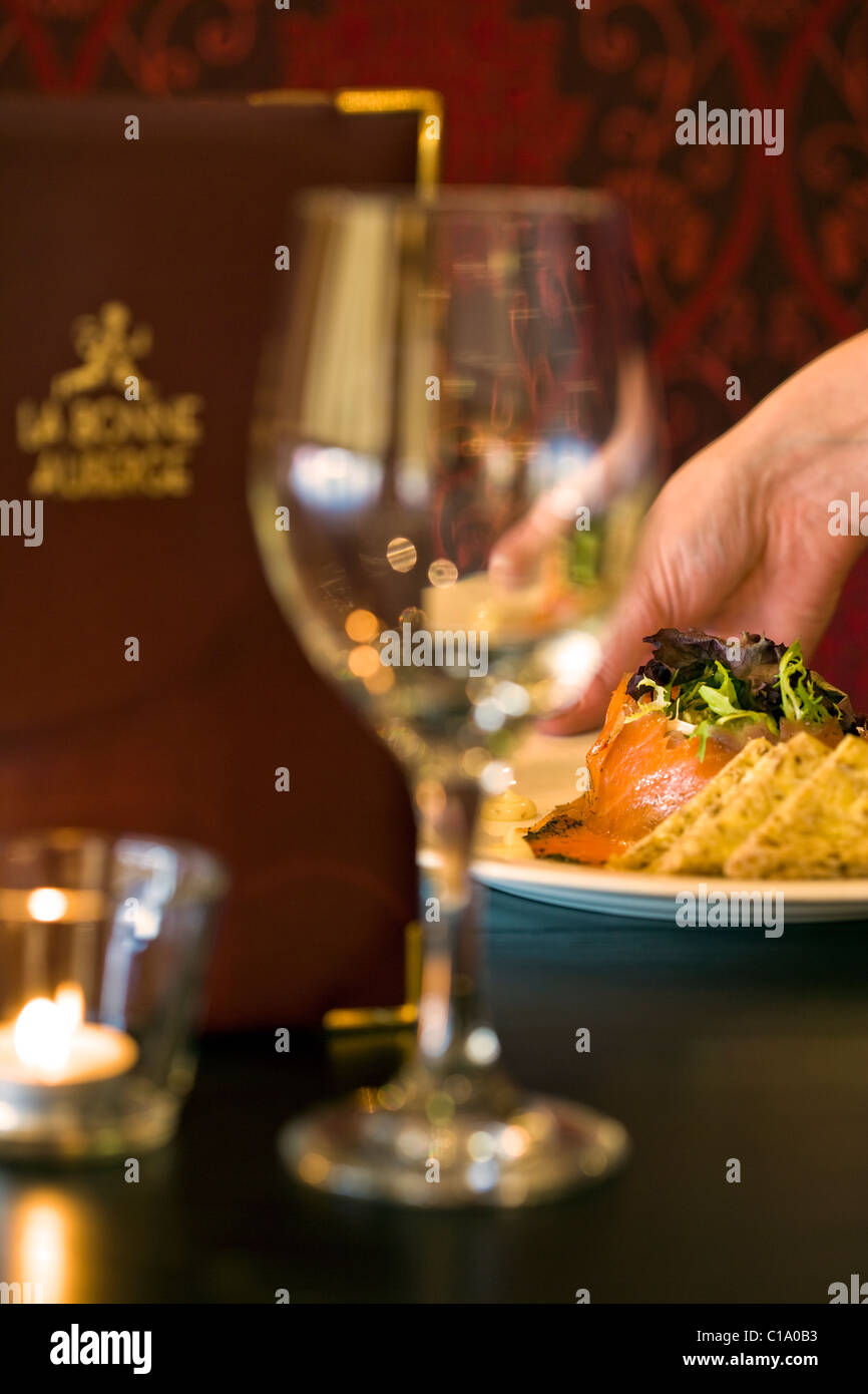 ABSTRACT SHALLOW FOCUS IMAGE OF A HAND DELIVERING FOOD IN A RESTAURANT Stock Photo
