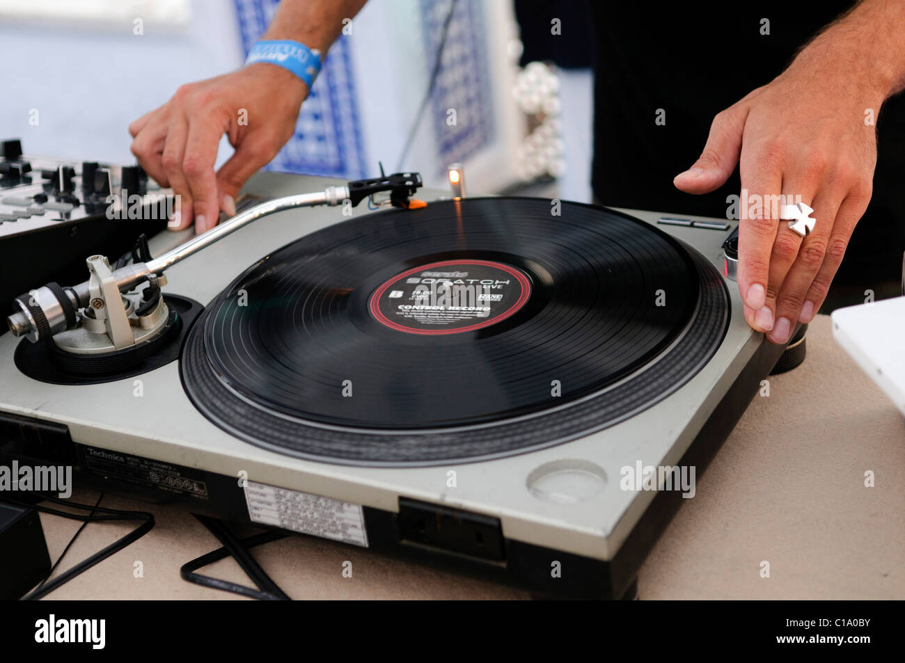 DJ performing live, mixing music using mixer and scratch vinyl record Stock Photo