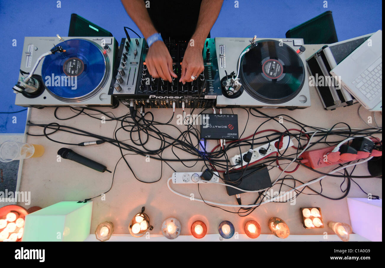 DJ performing live, mixing music using mixer and scratch vinyl record