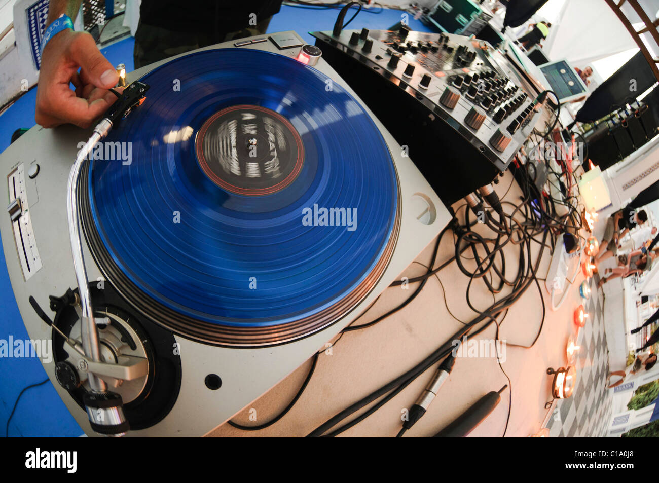 DJ performing live, mixing music using mixer and scratch vinyl record