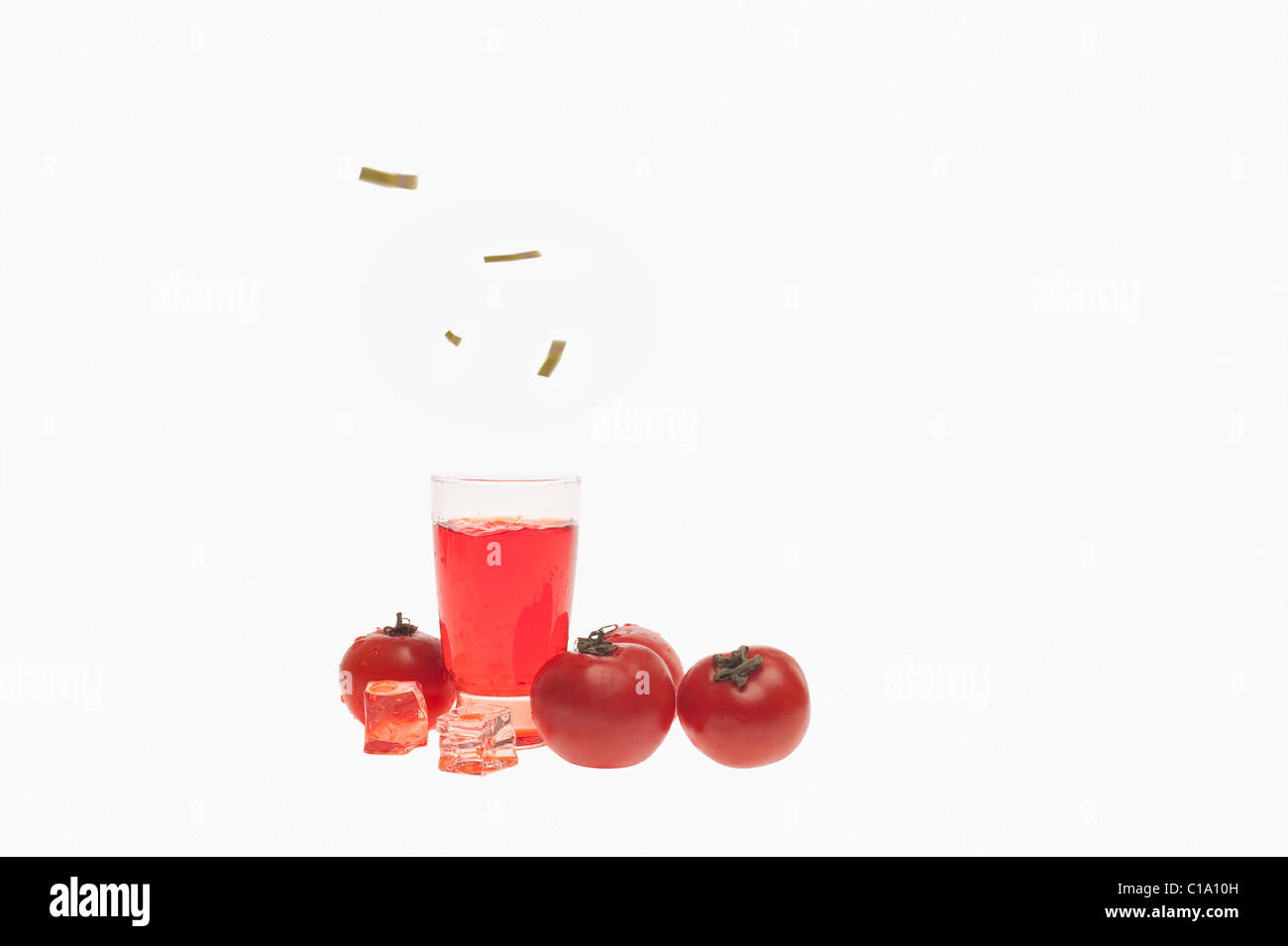 Close-up of tomatoes with a glass of tomato juice Stock Photo
