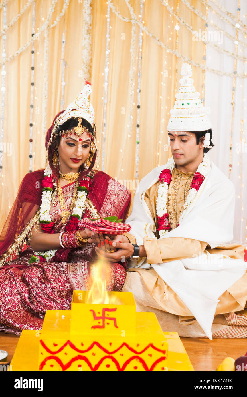 Couple performing religious ceremony in Bengali wedding Stock Photo - Alamy