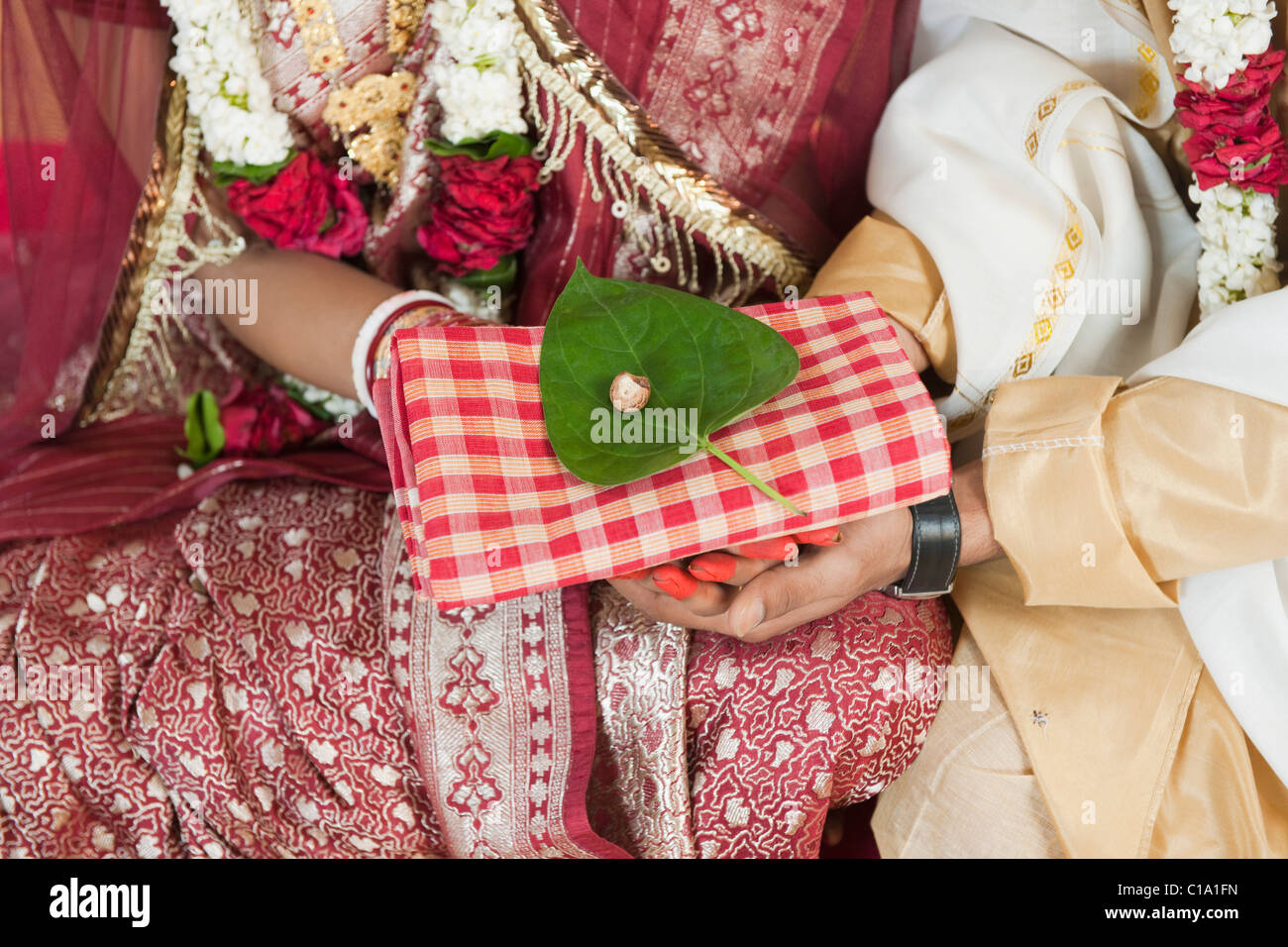 Mid section view of a couple performing religious ceremony in Bengali wedding Stock Photo