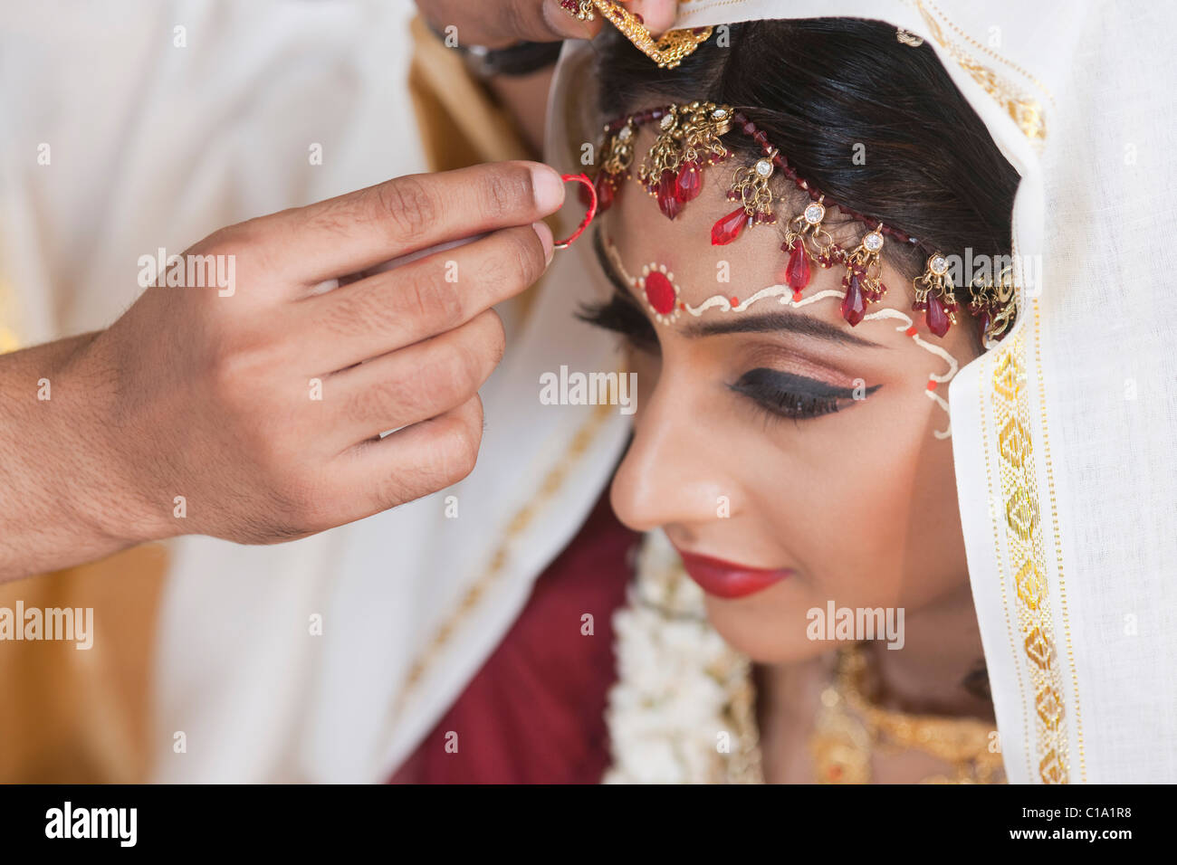 Couple performing Sindoor Daan ceremony in Bengali wedding Stock Photo