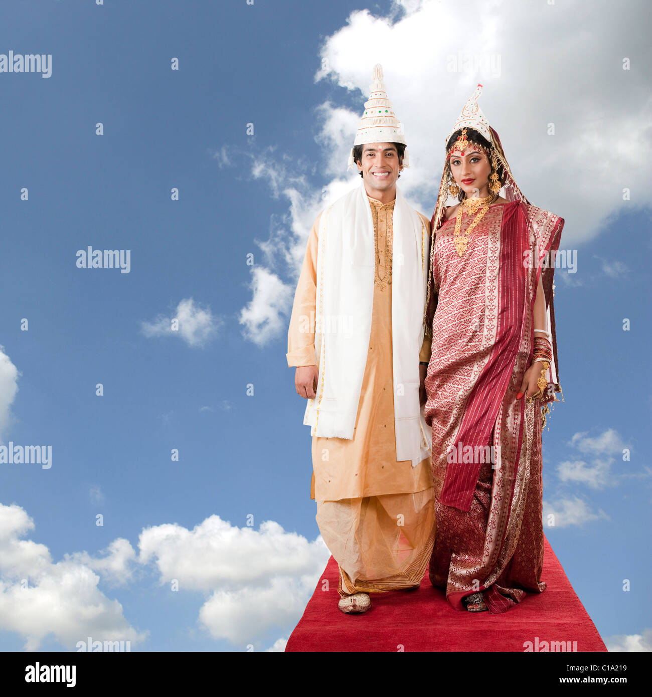 Newlywed couple standing on a carpet in clouds Stock Photo