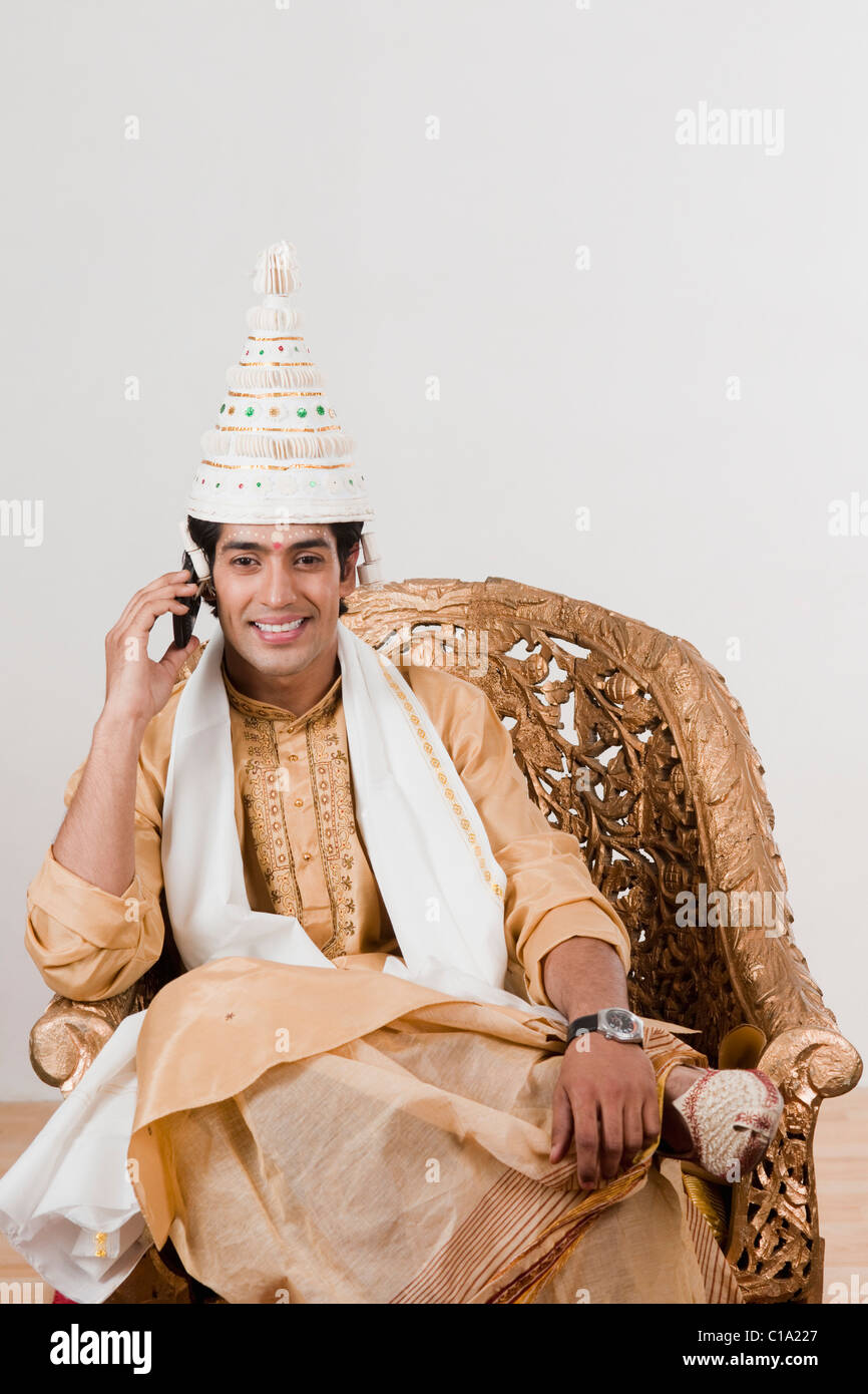 Bridegroom wearing a topor and talking on a mobile phone Stock Photo