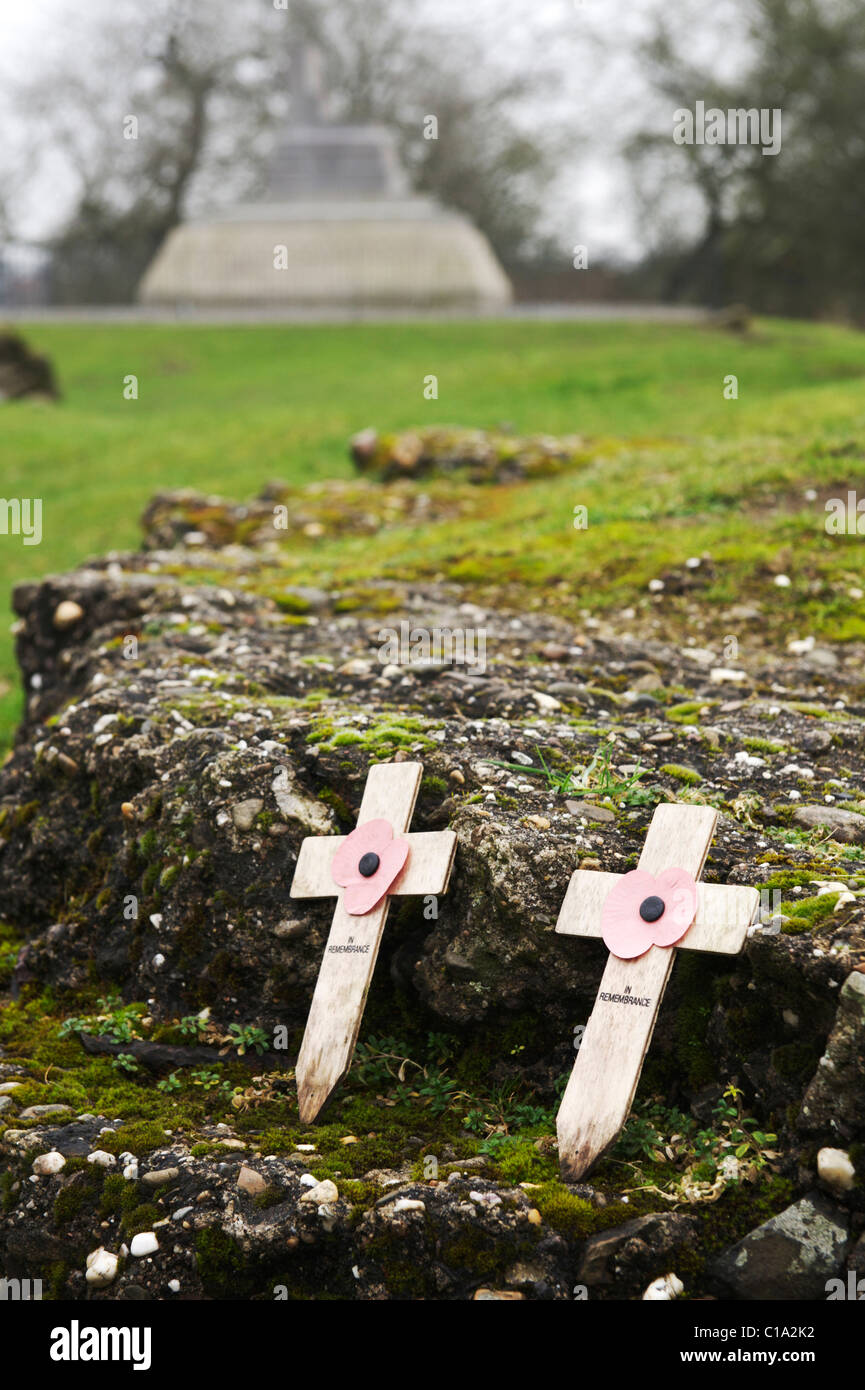 two 'in remembrance' crosses with poppies, resting against stone in Tyne Cot Cemetery Stock Photo