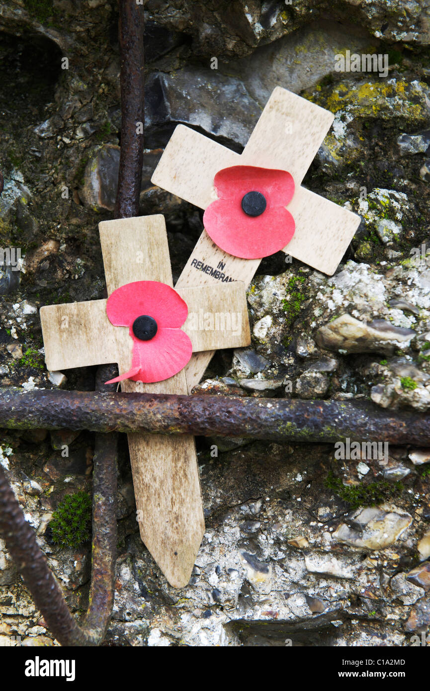 two 'in remembrance' crosses with poppies, resting against stone in Tyne Cot Cemetery Stock Photo