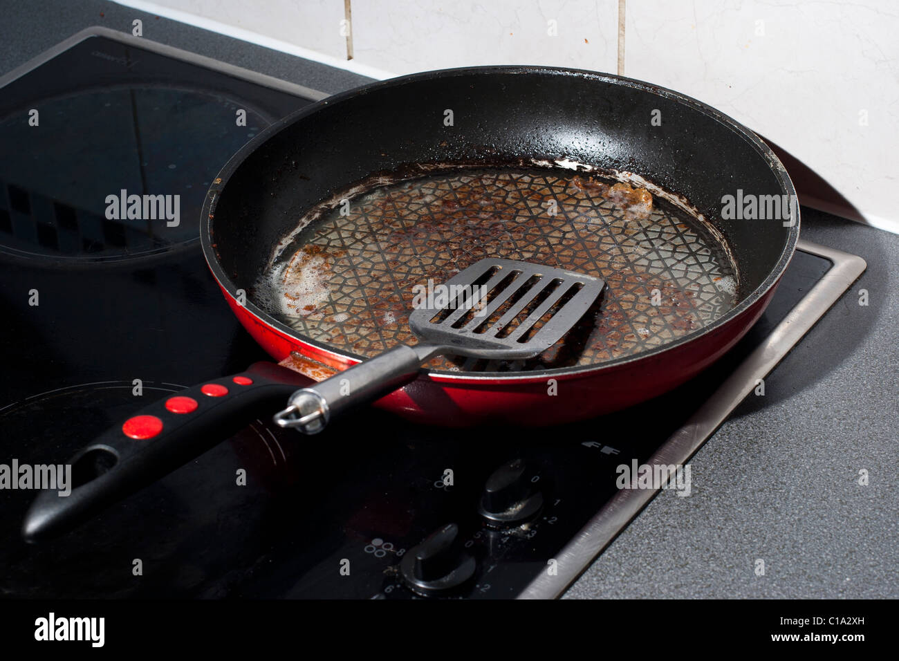 A Dirty Frying Pan on a Black Electric Hob Stock Photo Alamy