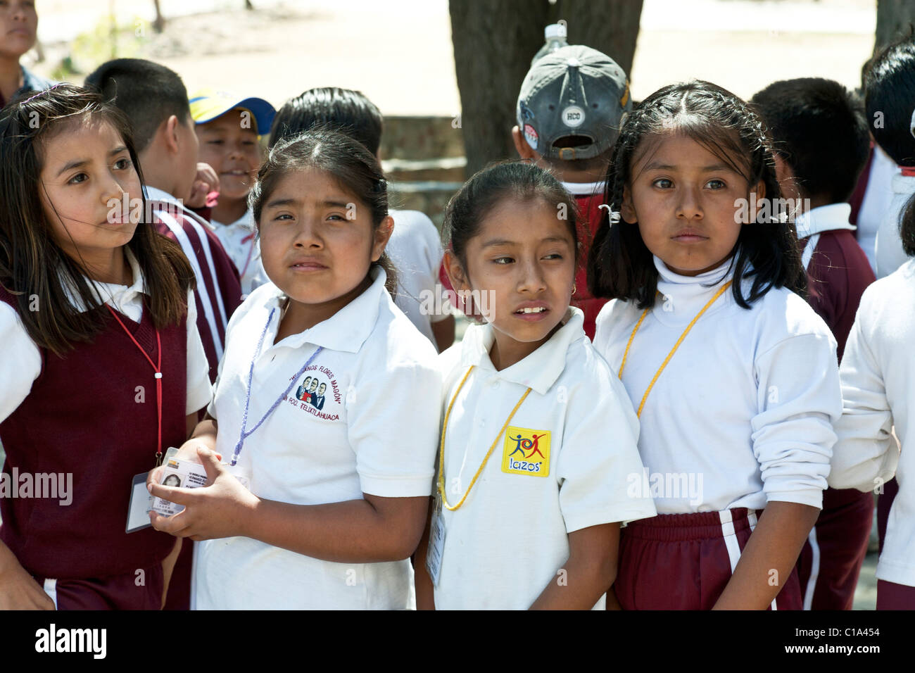 faces of young Mexican girls grade school children on school outing to ruins of ancient Zapotec capital city of Monte Alban Stock Photo