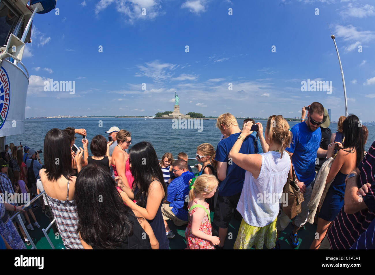 Tourists cruise by Statue of Liberty in New York Harbor taking pictures