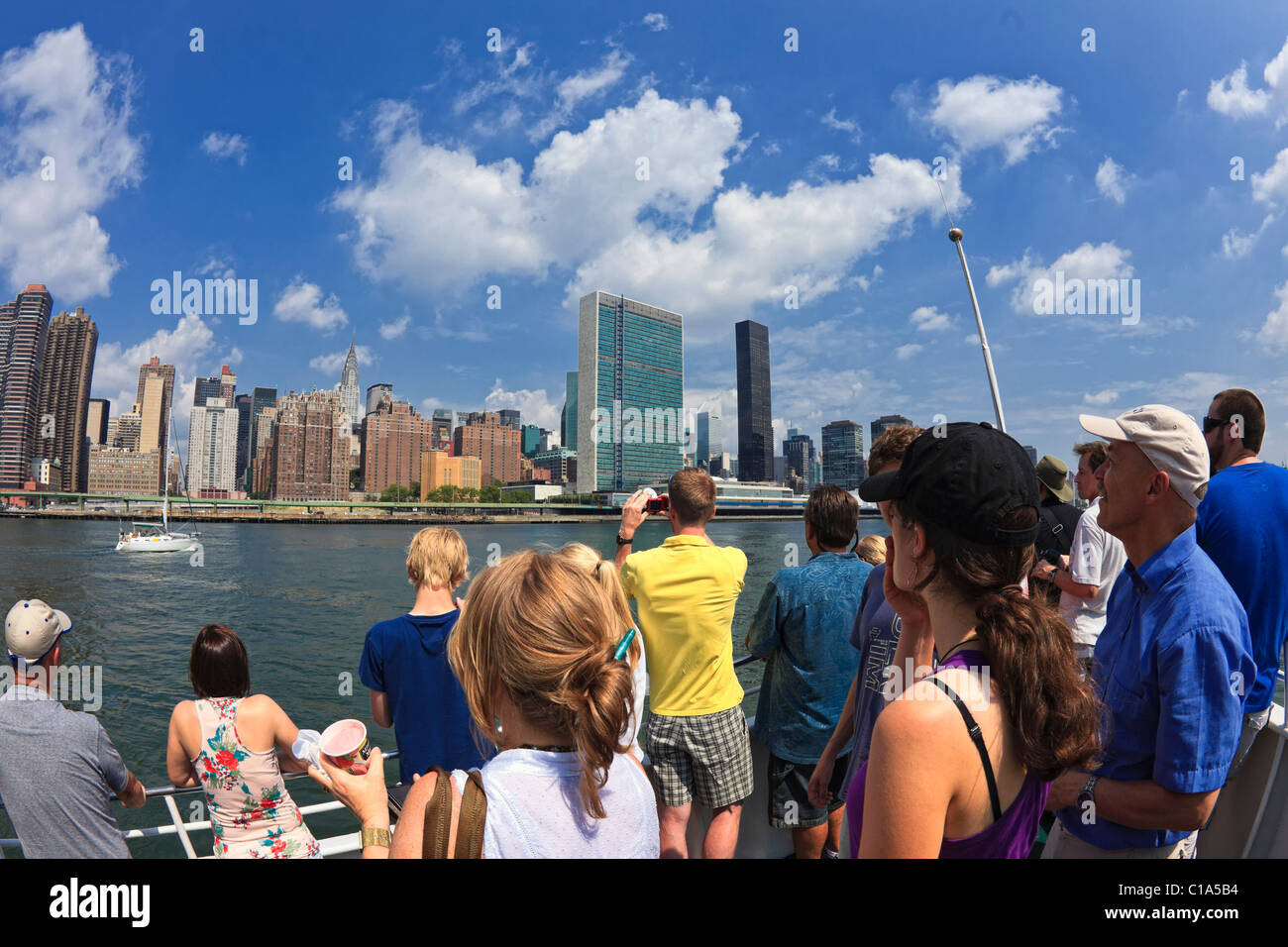 Cruise line tourists photograph Manhattan near United Nations from East River. Stock Photo
