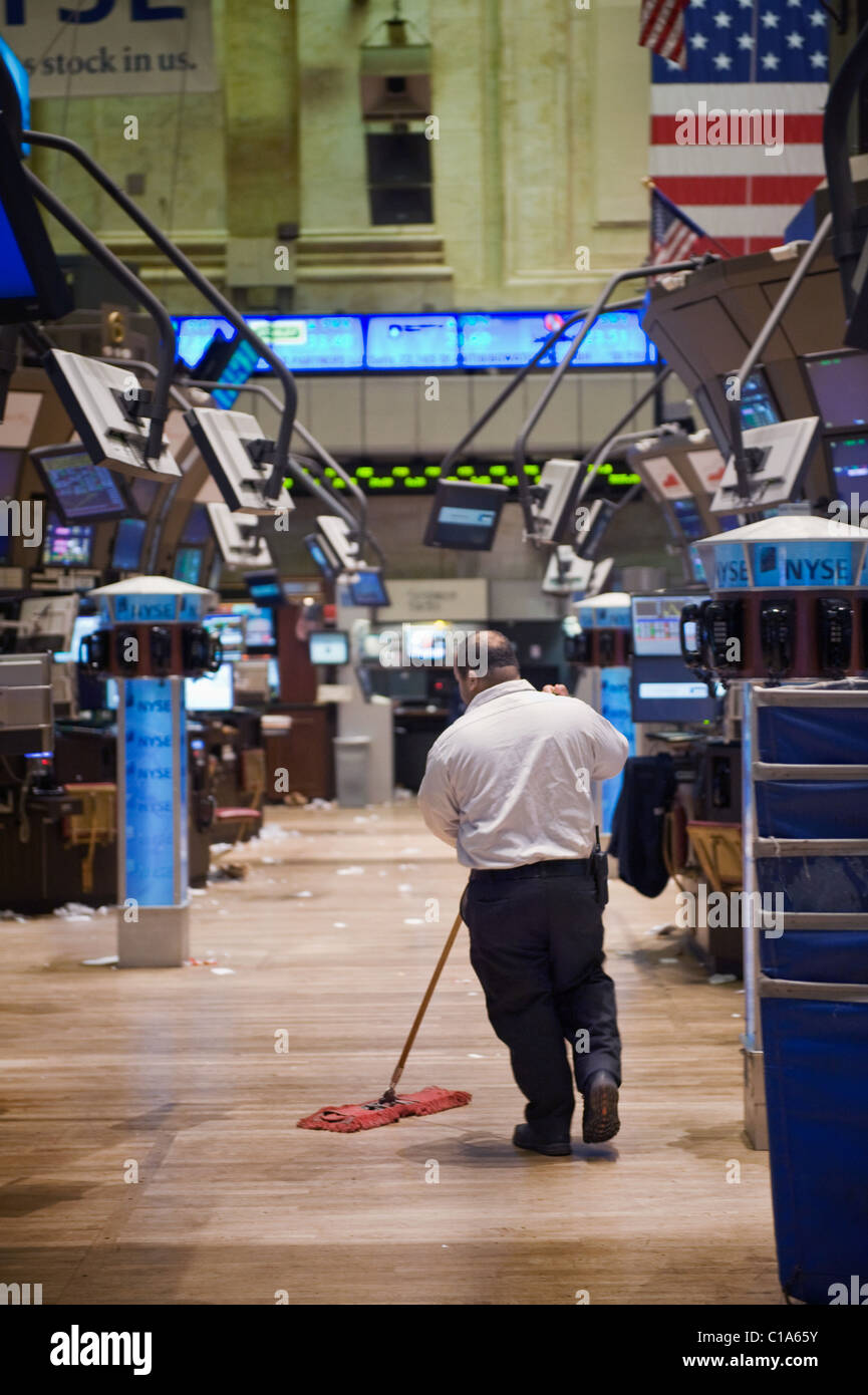 A janitor sweeping the floor of the New York Stock Exchange after a slow day of trading. Stock Photo