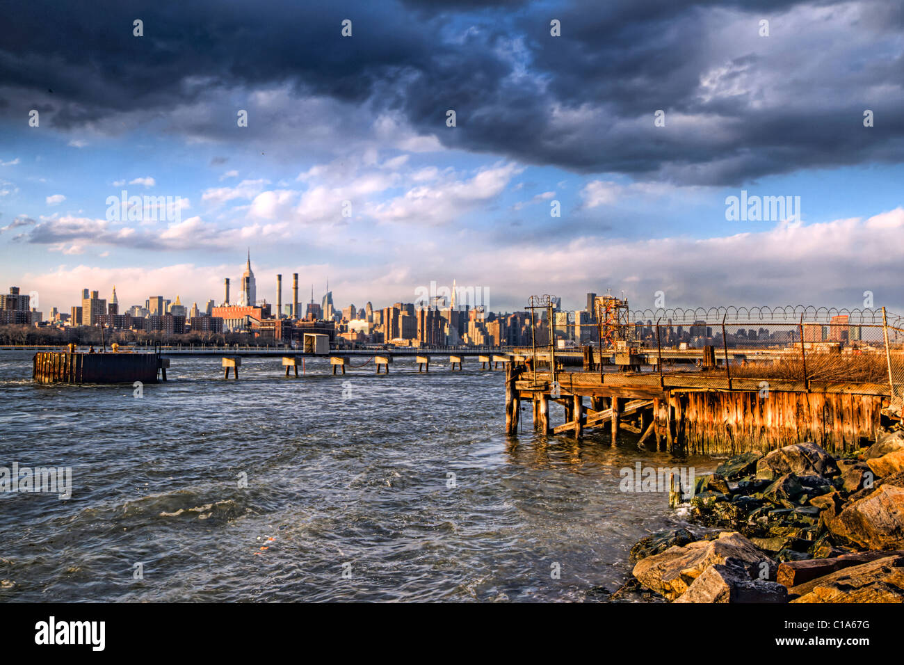 Midtown Manhattan under a dramatic sky seen from the Williamsburg section of Brooklyn across the East River Stock Photo