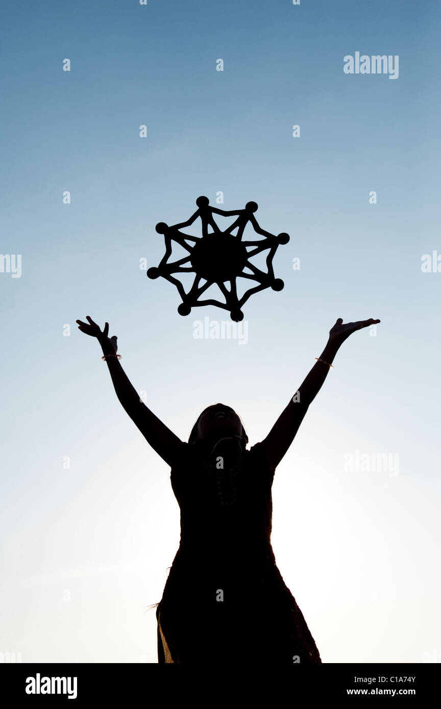 Silhouette indian girl throwing a symbol of one world, unity and humanity into the air. India Stock Photo