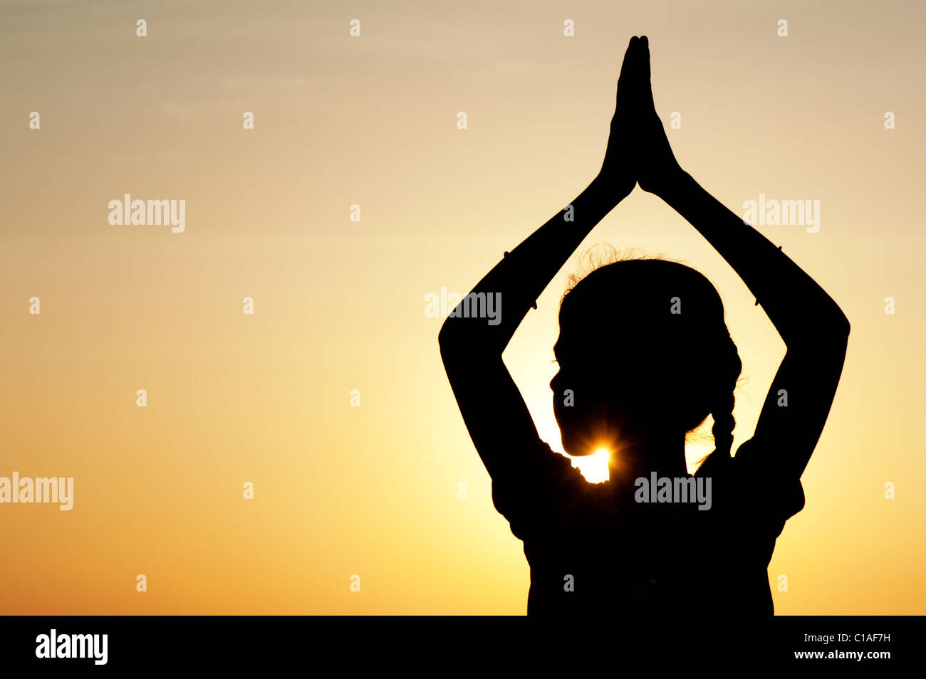 Indian girl praying at sunset. Silhouette. India Stock Photo