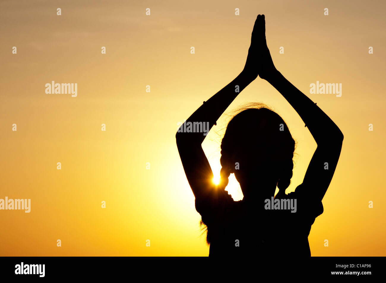 Indian girl praying at sunset. Silhouette. India Stock Photo