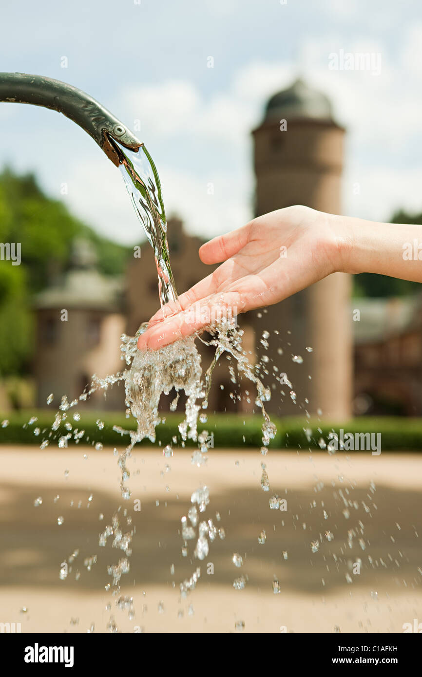 Woman with hand in water fountain, close up Stock Photo