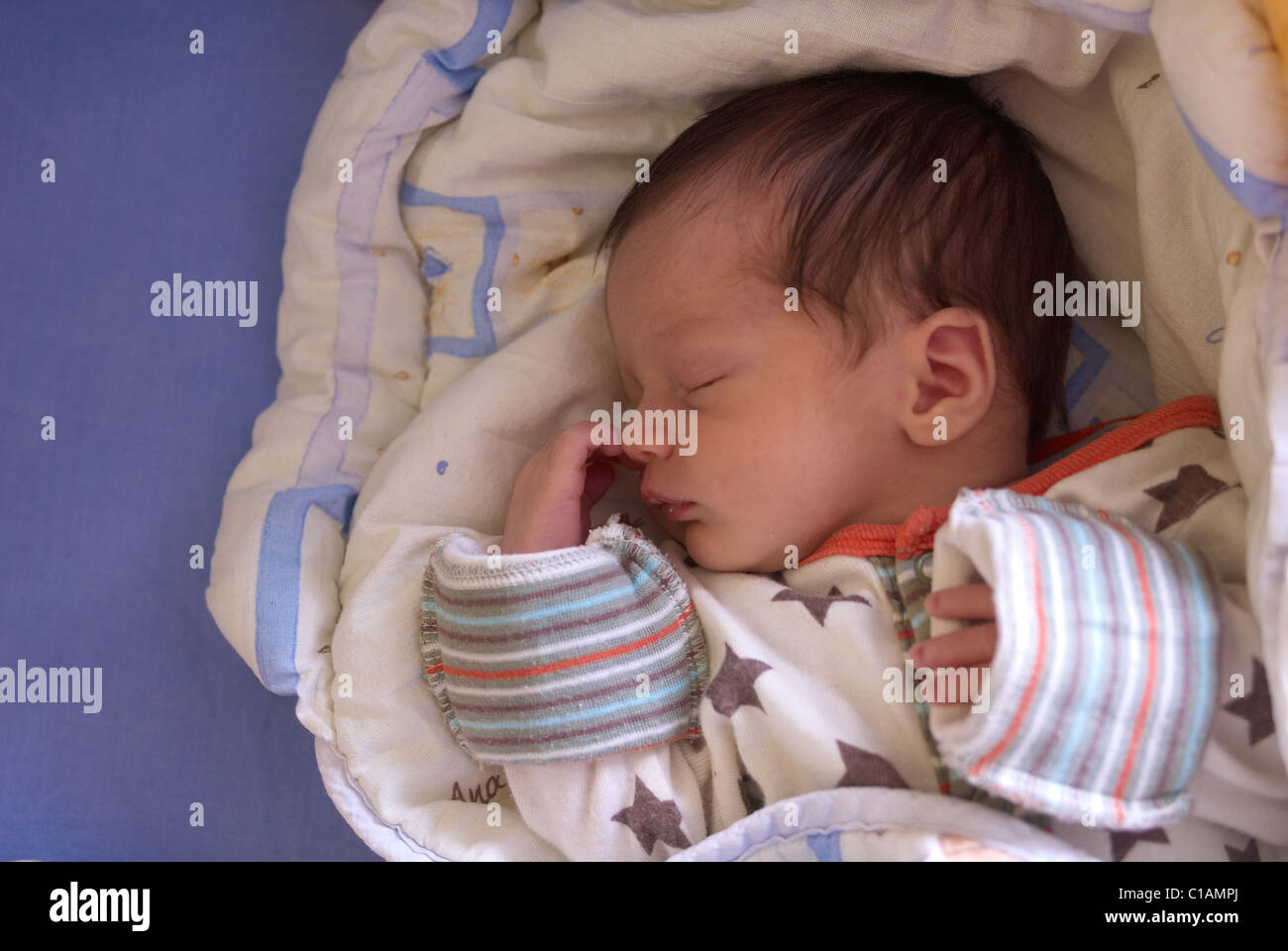 Baby girl sleeping in crib on quilt Stock Photo Alamy