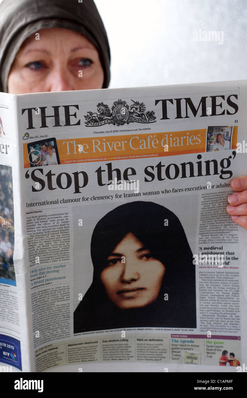 Woman reading The Times newspaper with headline 'Stop the stoning'. Stock Photo