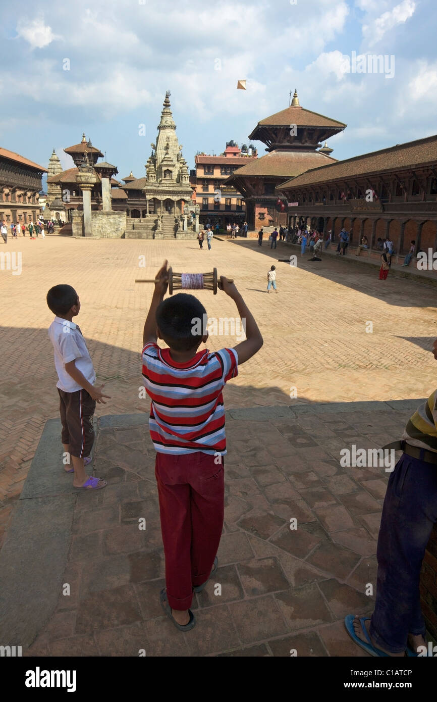 Young boy flying kite in Durbar Square in the UNESCO World Heritage city of Bhaktapur, Kathmandu Valley, Nepal, Asia Stock Photo