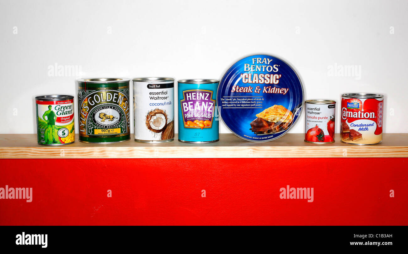 A row of tinned goods sit on a shelf Stock Photo
