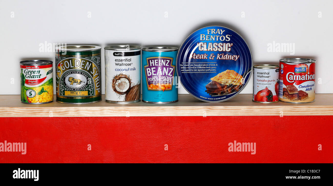 A row of tinned goods sit on a shelf Stock Photo