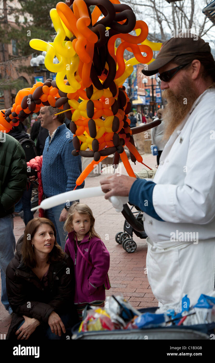 Boulder, Colorado - A man makes makes a balloon sculpture for a child on the Pearl Street Mall Stock Photo