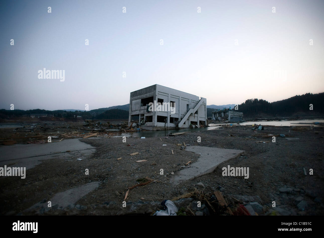A building lies removed from its foundations after the mega-tsunami in Minami-Sanriku, a coastal town in northeast Japan Stock Photo
