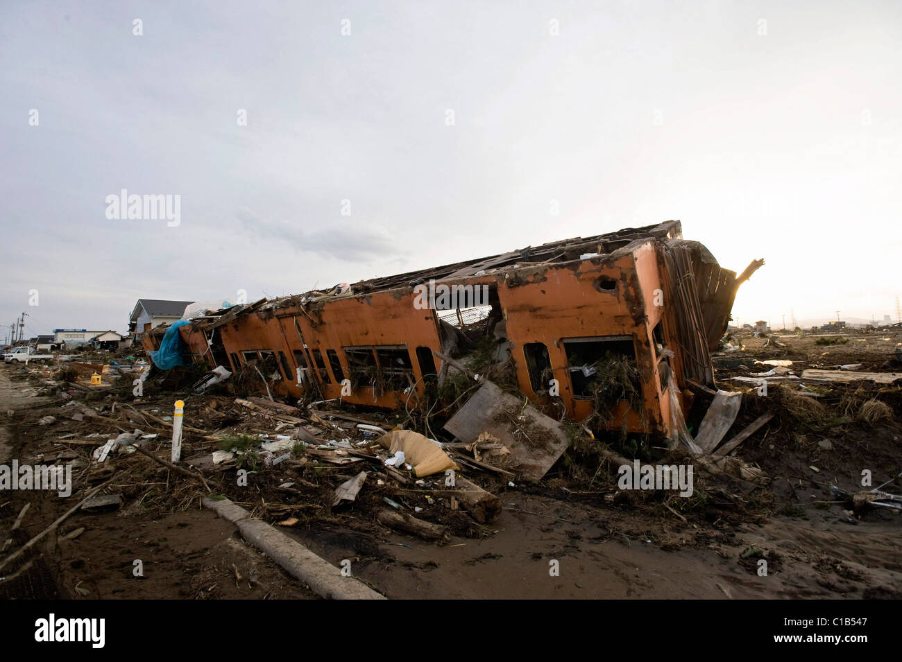 The carriage of a train lies in a field of debris from the mega-tsunami that followed the March 11 magnitude 9 quake in Sendai Stock Photo