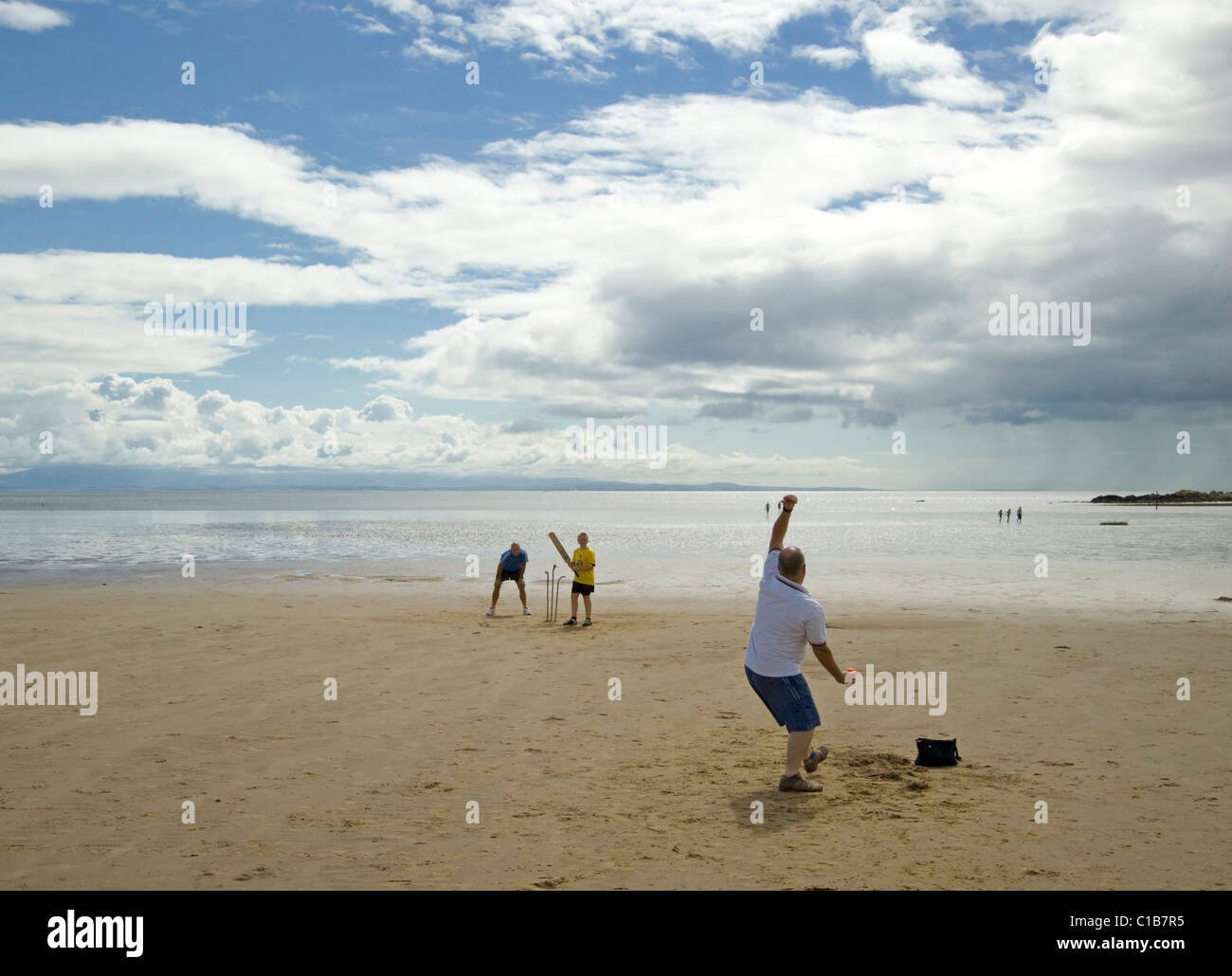 Playing cricket on beach at Sandyhills, galloway with homemade wickets Stock Photo