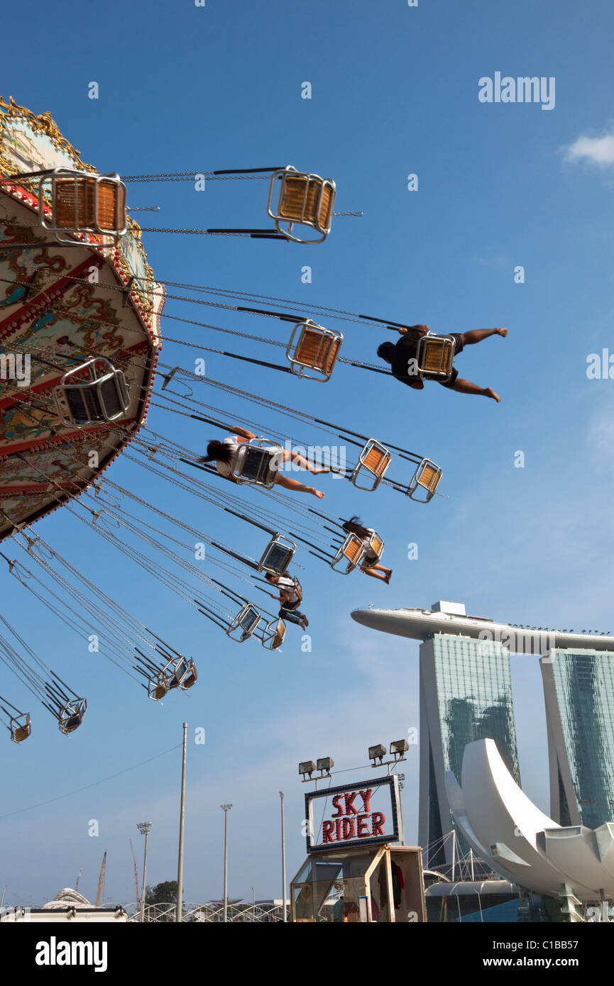 Amusement ride with Marina Bay Sands Hotel in the background.  Marina Bay, Singapore. Stock Photo