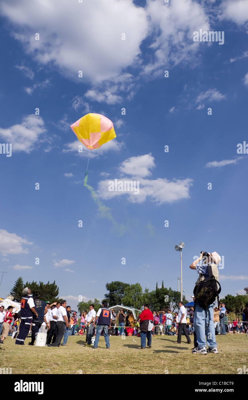 Crowd watching a Globo de Cantolla (hot air paper balloon) releasing green  smoke in San Agustin Ohtenco, Mexico Stock Photo - Alamy