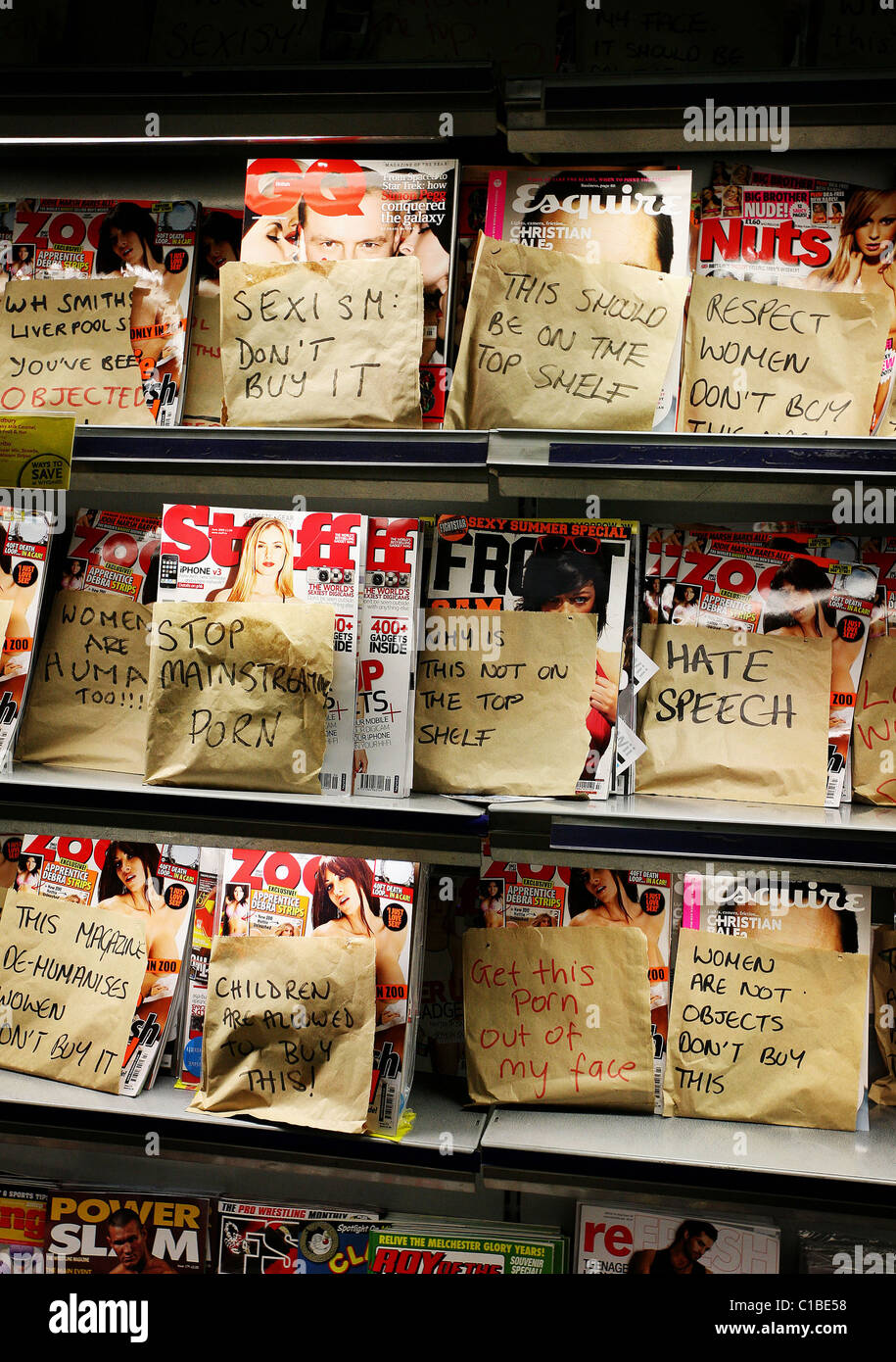 Women from 'Object' - a protest group put down paper bags over lads mags in WH Smiths Liverpool Street. Stock Photo