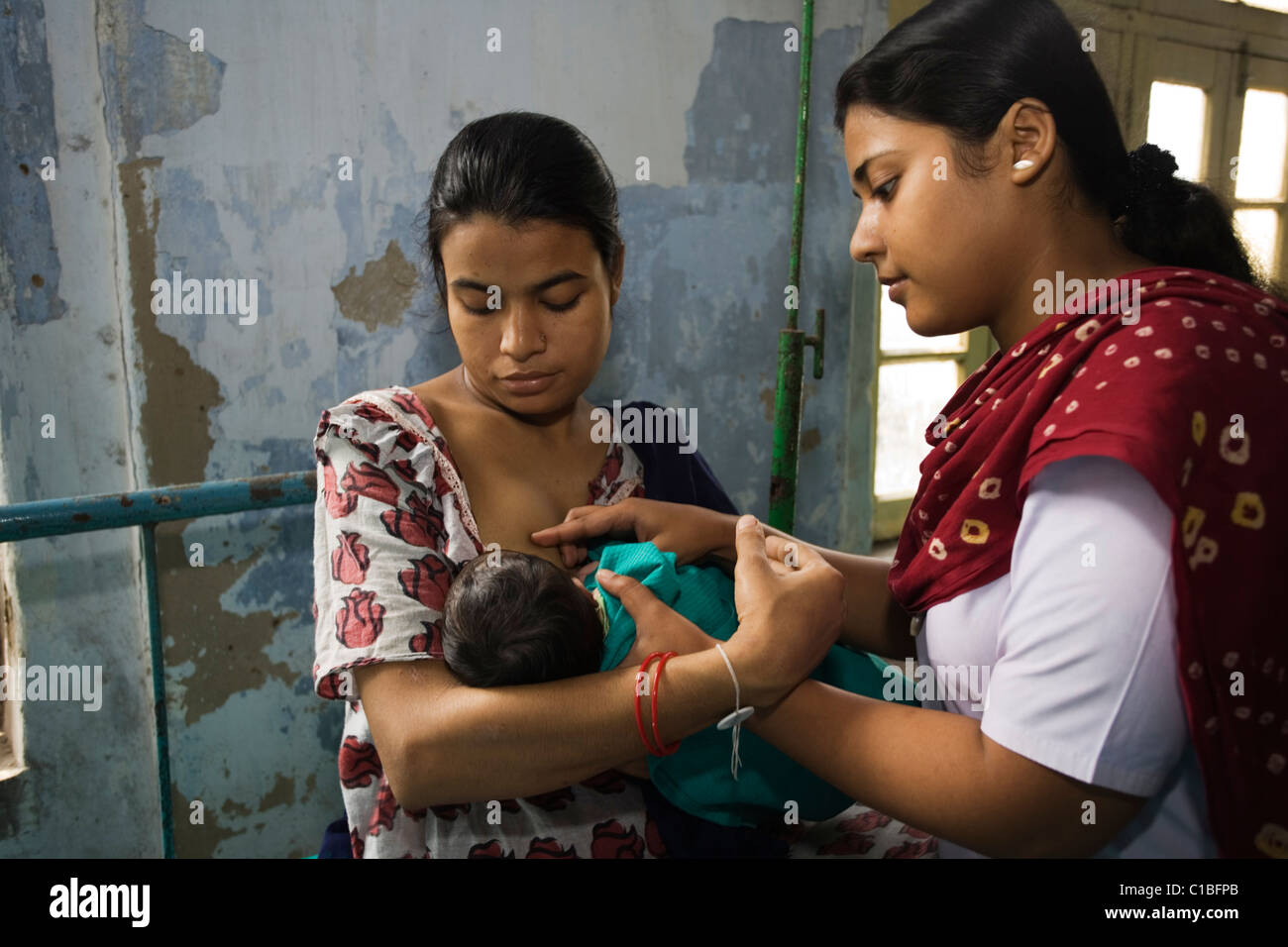 Midwife helps new mother with breastfeeding, Kolkata Nursing College