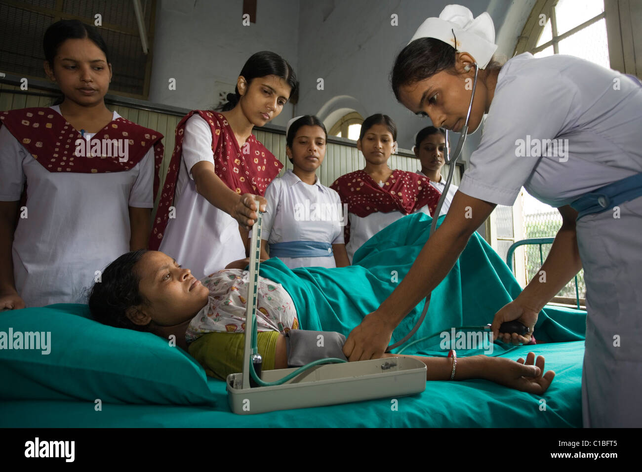 Trainee midwives at Kolkata Nursing College are measuring woman's blood pressure, Kolkata, India Stock Photo