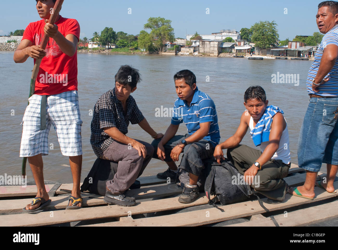 A  homemade raft made of truck tire tubes and boards carries people across the Suchiate River from Guatemala to Mexico. Stock Photo