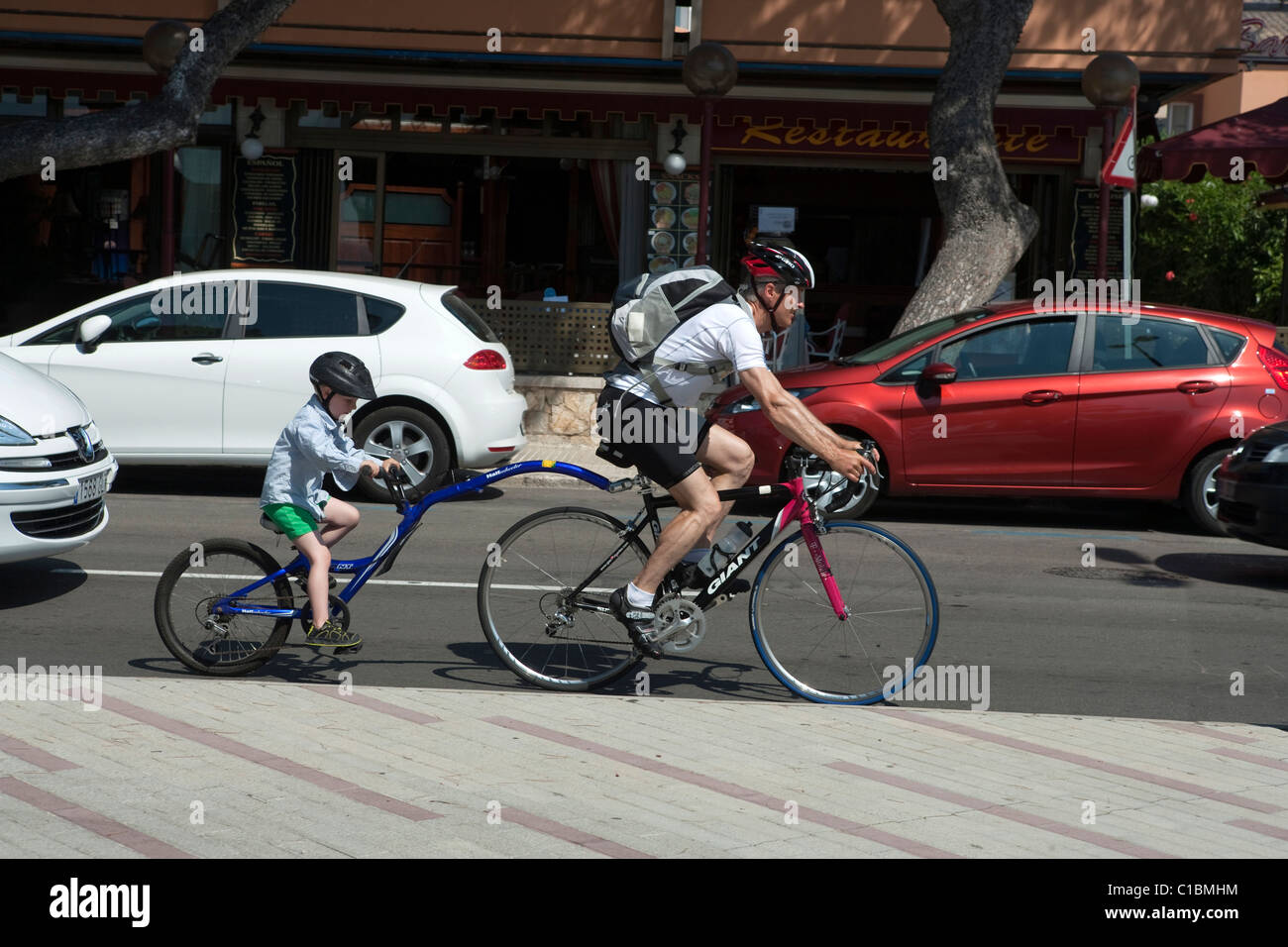tandem bicycle father with son cycling on street in Mallorca Majorca