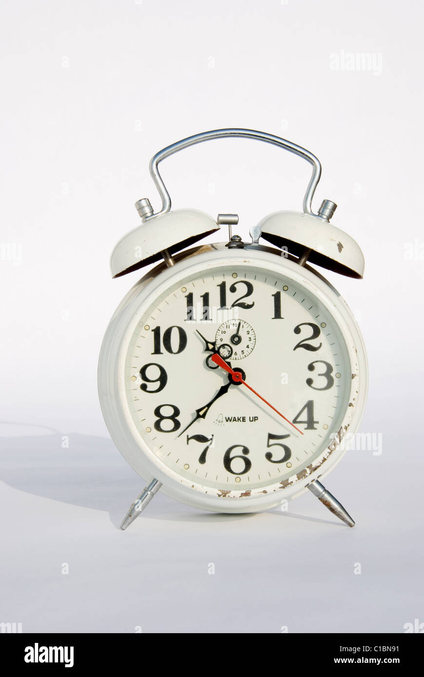 Old white mechanical alarm clock on a white background Stock Photo - Alamy
