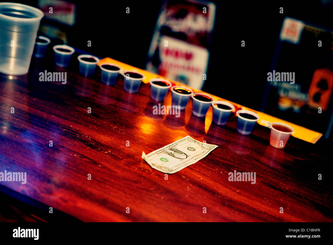 ALCOHOL DRINKS SHOTS WHISKEY BRANDY ROW TIP MONEY DOLLAR USA BAR COUNTER AMERICAN ONE DRINK DRINKING Stock Photo