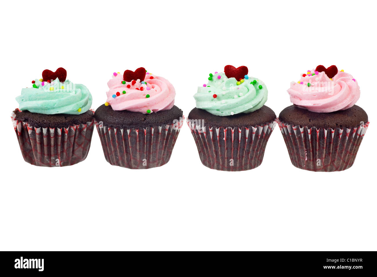 Four cupcakes in a row isolated on white background Stock Photo