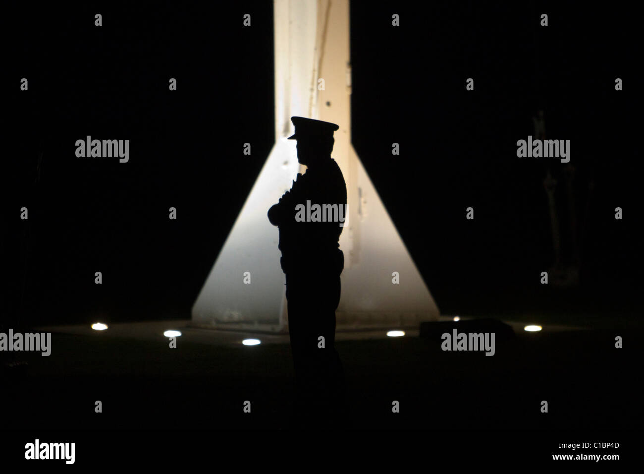 A lone police officer guards the flagpole as the Prime Minister John Key attends the Dawn Service Stock Photo