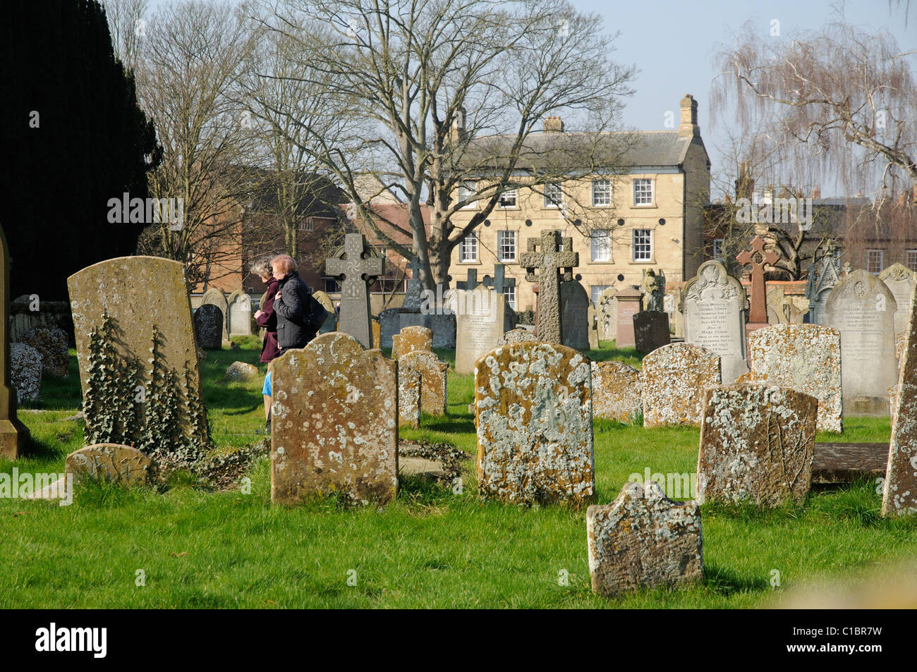 Graveyard and women walking to church at St Peter & St Paul Church in Olney Buckinghamshire England UK Stock Photo