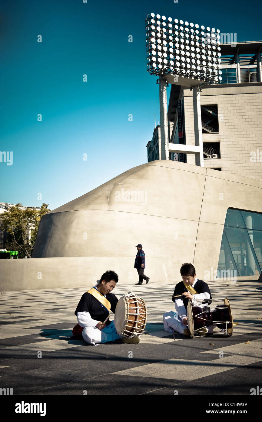 Traditional drummers in front of  Zaha Adid's architecture, Dongdaemun Design Plaza & Park, Seoul, South Korea, Asia Stock Photo