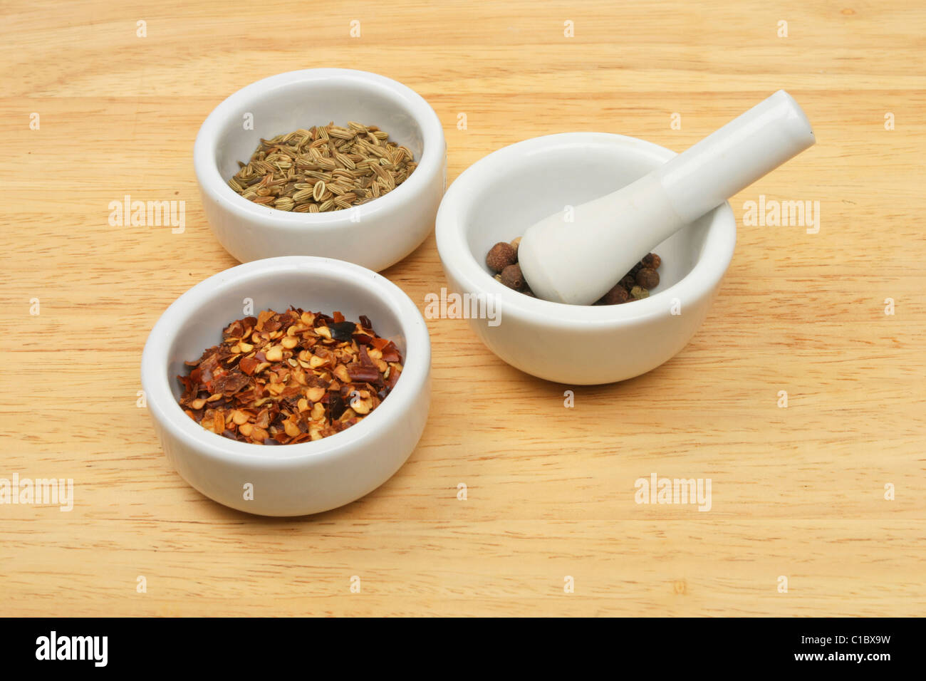 Spices in a ramekins and a pestle and mortar Stock Photo