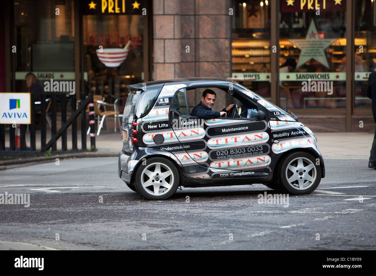 Man driving a Smart Car in London. This microcar design was devised to